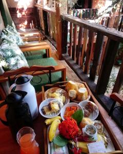 una bandeja de comida en una mesa en un balcón en Sanctuary Pirenópolis Suítes e Flats, en Pirenópolis