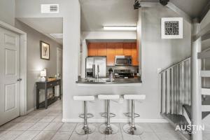 a kitchen with a counter and stools in a room at King Beds and Patio Dining in ATX West Campus Gem in Austin