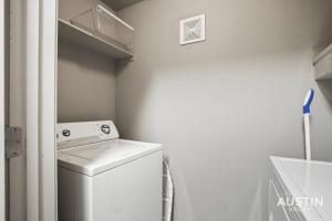 uma pequena lavandaria com uma máquina de lavar roupa em King Beds and Patio Dining in ATX West Campus Gem em Austin