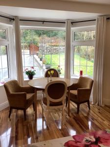 a dining room with a table and chairs and windows at O' Sullivan's B & B in Killarney