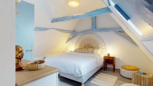 a bedroom with a white bed with blue beams at Demeure du Vallon - Chambres d'Hôtes de Charme in Azerat