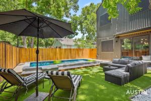 einen Hinterhof mit Pool und Sonnenschirm in der Unterkunft Modern Luxury Home - Minutes from Lady Bird Lake in Austin