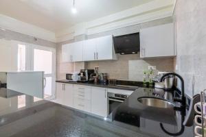 a kitchen with white cabinets and a sink at Appartement 2 chambres in Marrakesh