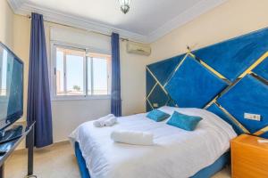 a bedroom with a blue and white bed and a tv at Appartement 2 chambres in Marrakesh