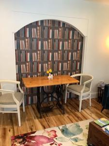 een bibliotheek met een houten tafel en 2 stoelen bij O' Sullivan's B & B in Killarney