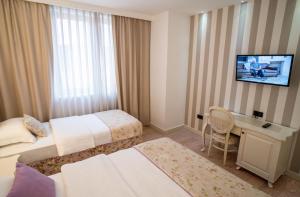 Pokój hotelowy z 2 łóżkami i biurkiem w obiekcie Hotel Grace w Medziugorie