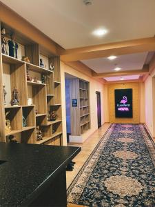 ドゥシャンベにあるFlamingoの大きな部屋で、棚とテレビ付きの図書室があります。