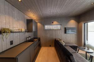 eine Küche und ein Wohnzimmer mit einem Sofa und einem Tisch in der Unterkunft Varanger View in Vardø