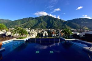 a swimming pool with a view of a city and mountains at Pestana Caracas Premium City & Conference Hotel in Caracas
