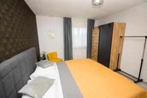 um quarto com uma cama e um cobertor amarelo em Apartman Lipa em Slavonski Brod