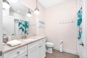 ein weißes Badezimmer mit Waschbecken und Toilette in der Unterkunft Park 201 Downtown in the Heart of Traverse City in Traverse City + 26 Fotos