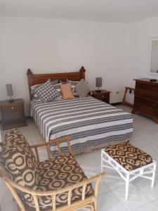 1 Schlafzimmer mit einem Bett und 2 Stühlen in der Unterkunft Seacastles in Montego Bay