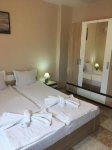a bedroom with a white bed with towels on it at Stoyko's Guest House in Pomorie