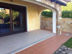 un patio con un arco y una pared de piedra en Casa Magnolia, en Porto San Paolo