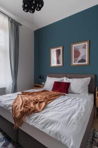 um quarto com uma cama grande e paredes azuis em MIZU House by Prague Days em Praga