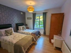 a bedroom with two beds and a window at O' Sullivan's B & B in Killarney