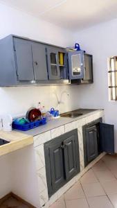 una cocina con armarios azules y fregadero en Maison individuelle cozy à OUEDO cotonou, 