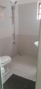 Baño blanco con aseo y lavamanos en Maison individuelle cozy à OUEDO cotonou, 