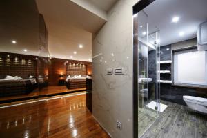 a bathroom with a shower and a sink and a bed at Deluxe Dino room in Zadar