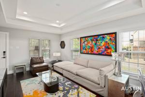 a living room with a couch and a painting on the wall at Walk to UT and E 6th in Fully Equipped ATX House in Austin