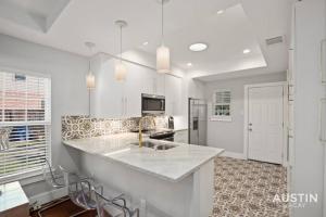 a kitchen with white cabinets and a counter top at Walk to UT and E 6th in Fully Equipped ATX House in Austin