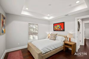 een slaapkamer met een bed en een raam bij Walk to UT and E 6th in Fully Equipped ATX House in Austin
