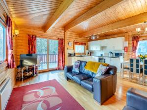 a living room with a couch and a kitchen at Forest Lodge in Legbourne