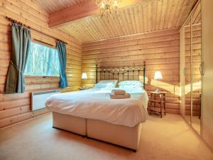 um quarto com uma cama num chalé de madeira em Forest Lodge em Legbourne