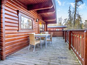 a wooden deck with a table and chairs on it at Forest Lodge in Legbourne