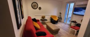 a living room with a red couch and a clock on the wall at Superbe T2, Vieux Port, Hyper centre Ajaccio in Ajaccio