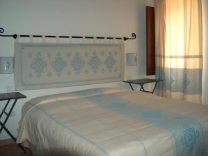 una camera da letto con un grande letto con due tavoli di Guest House Il Giardino Segreto a Cagliari