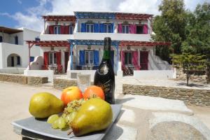 um prato de fruta numa mesa com uma garrafa de vinho em Drosoulites em Agios Ioannis