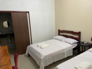 una camera d'albergo con due letti e un tavolo con sedie di Milagres do Camaragibe a Passo de Camarajibe