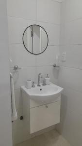 Baño blanco con lavabo y espejo en Departamento espectacular vista a la Ciudad en El Challao