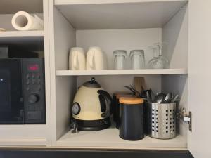 un armario con tetera y otros utensilios de cocina en Studio Plac Narutowicza, en Varsovia