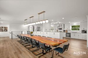 cocina grande con mesa de madera grande y sillas en Capitol View 4k sqft Dwntwn Penthouse w 17ft Table, en Austin