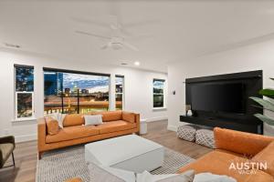 a living room with a couch and a flat screen tv at Capitol View DT w Elevator with Free Swim Club Access in Austin