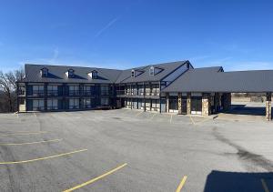 a large building with a parking lot in front of it at Branson Ozarks Inn in Branson