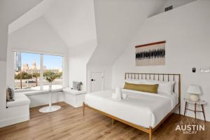 a white bedroom with a bed and a window at Capitol View DT w Elevator with Free Swim Club Access in Austin