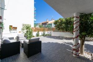 a patio with couches and chairs on a patio at Caparica Sun Beach Villa in Charneca