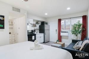 a white room with a bed and a kitchen at Cozy Newly Renovated King Sofa Bed and Smart TV in Austin