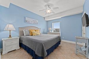 a blue bedroom with a bed and a ceiling fan at Twin Palms 1705 in Panama City Beach