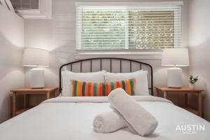 オースティンにあるIndulge in Downtown Austin Apt Near Zilker Parkのベッドルーム1室(白いベッド1台、ランプ2つ付)