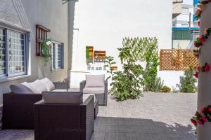 a patio with a couch and chairs on a patio at Caparica Sun Beach Villa in Charneca