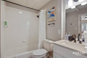オースティンにあるIndulge in Downtown Austin Apt Near Zilker Parkのトイレと洗面台を備えた白いバスルーム