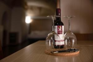 two wine bottles and glasses on a table at Residence Le Vie Del Mosto in Matera