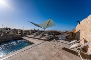 a patio with chairs and a swimming pool on a roof at Palazzo Bifora in Mdina