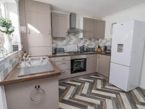 a kitchen with a white refrigerator and a sink at 2 Rowan Walk in Hornsea