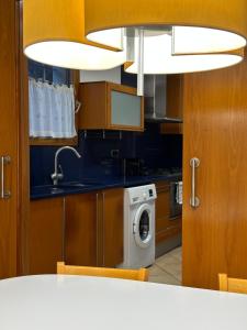 a kitchen with a washing machine and a sink at Chic apartment beach in Mataró