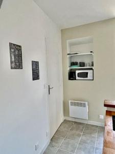 eine Küche mit einer Tür und einer Mikrowelle an der Wand in der Unterkunft * Au centre de la ville haute D * ZEN LOC 5 in Provins